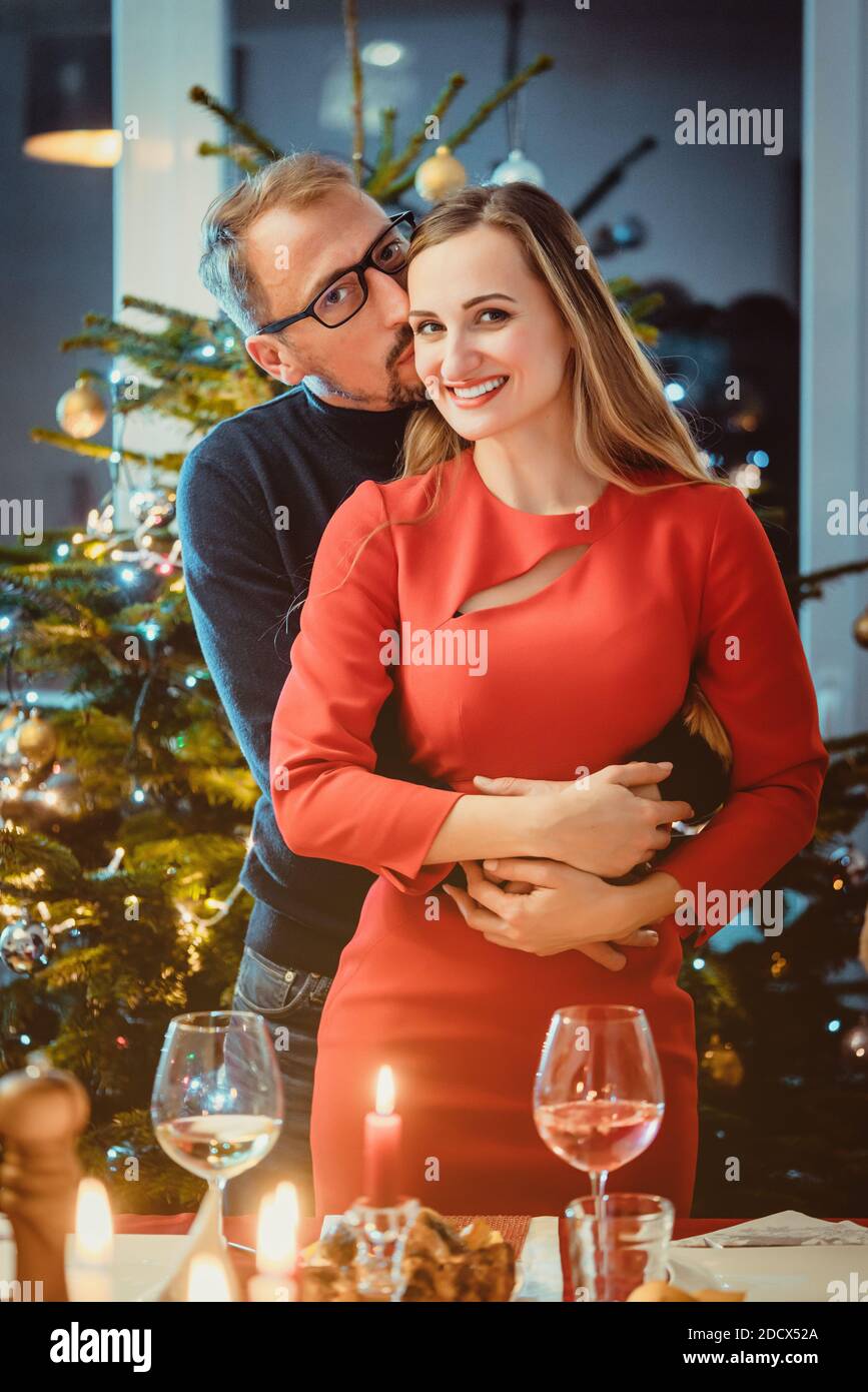 Ehepaar mittleren Alters in romantischer Pose vor Weihnachten Baum Stockfoto