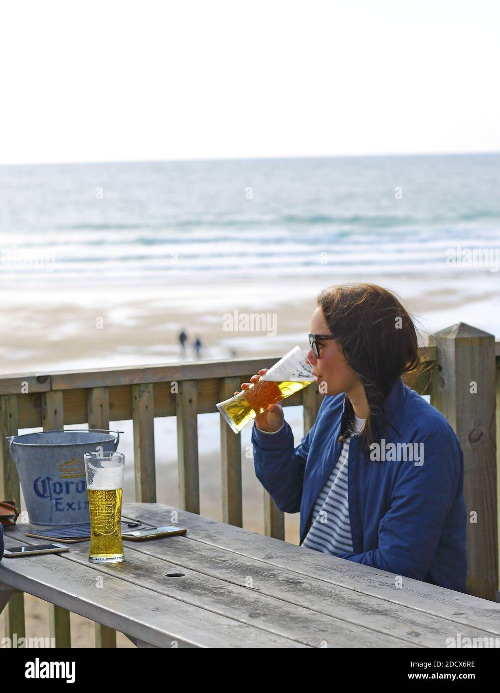 GROSSBRITANNIEN /Cornwall/ Newquay / Frau trinkt ein Bier in der Fistral Beach Bar und blickt ins Meer. Stockfoto