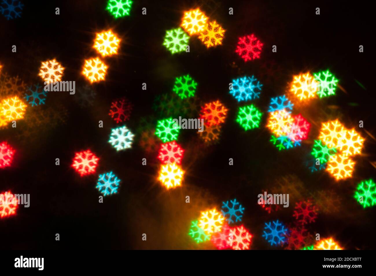 Weihnachten festliche Hintergrund. Verschwommener Weihnachtshintergrund, festliche Weihnachten mehrfarbige Bokeh Hintergrund in Form der Schneeflocken Stockfoto