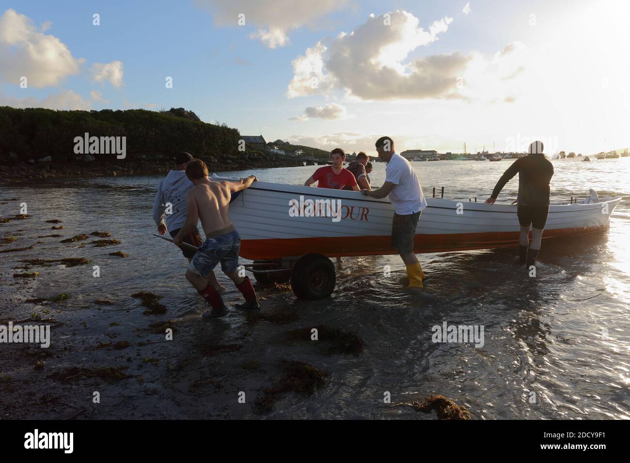 Die Crew von St. Mary’s Gig zieht das Boot nach dem Rennen an Land. Isles of Scilly, Cornwall, Großbritannien. Stockfoto