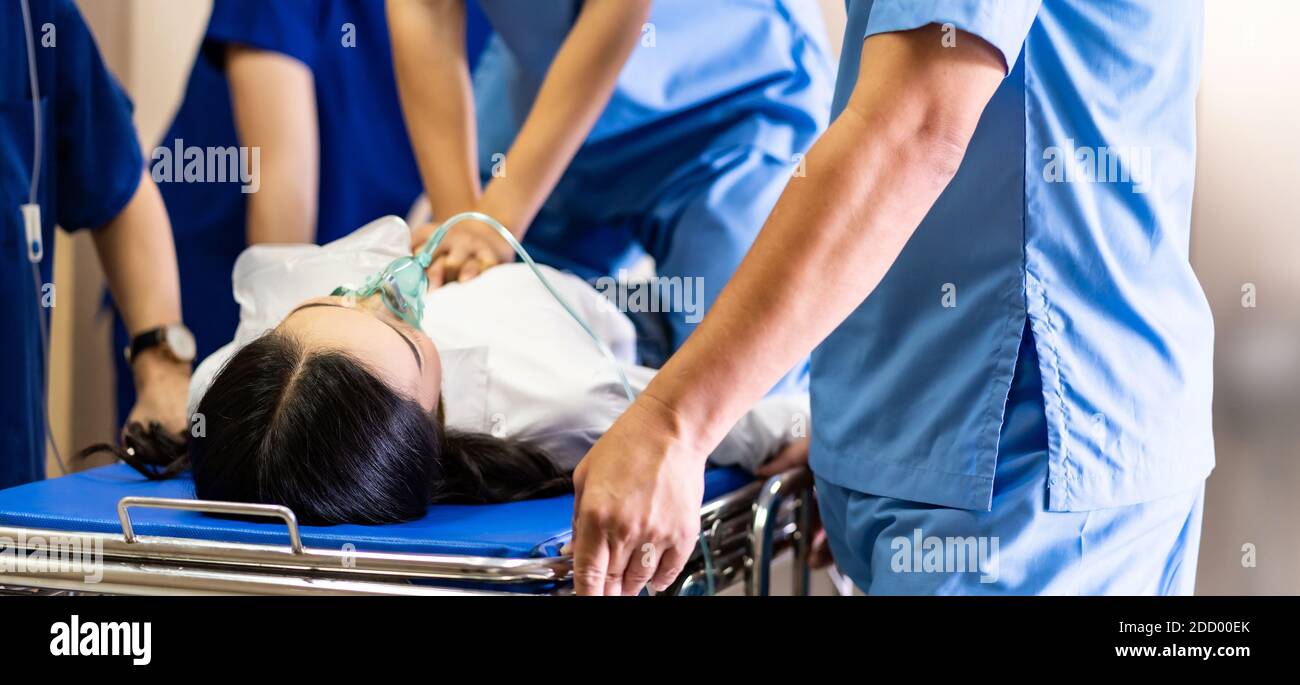 Panorama Nahaufnahme Ärztliche Team HLW bei schwer verletzten Patienten mit Sauerstoffmaske durchführen, während die Liege in den Operationssaal geschoben wird. Notfallheilung Stockfoto