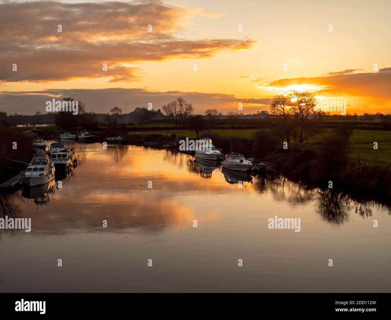 Schöner Sonnenuntergang Himmel spiegelt sich in der ruhigen Wasser des Flusses Ouse mit verankerten Booten in der Nähe von York, England Stockfoto