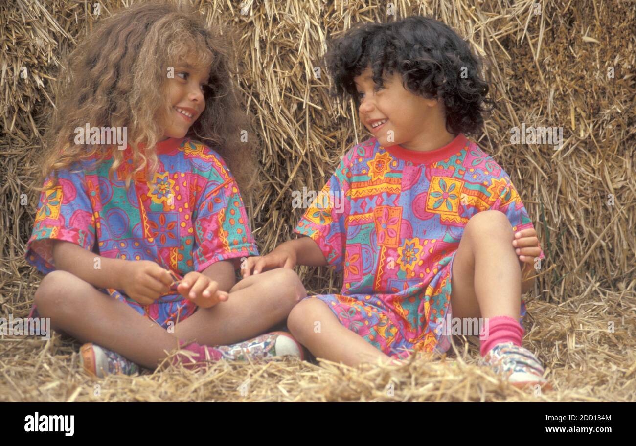 Zwei kleine Schwestern sitzen auf Heuballen und plaudern Stockfoto