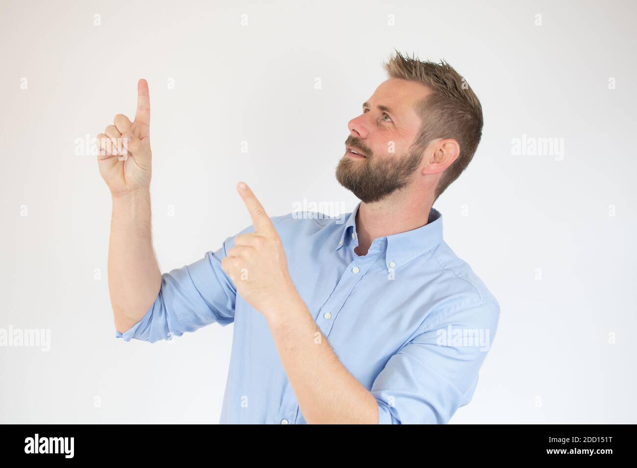 Schöner bärtiger Mann in lässiger Kleidung zeigt weg, auf weißem Hintergrund Stockfoto