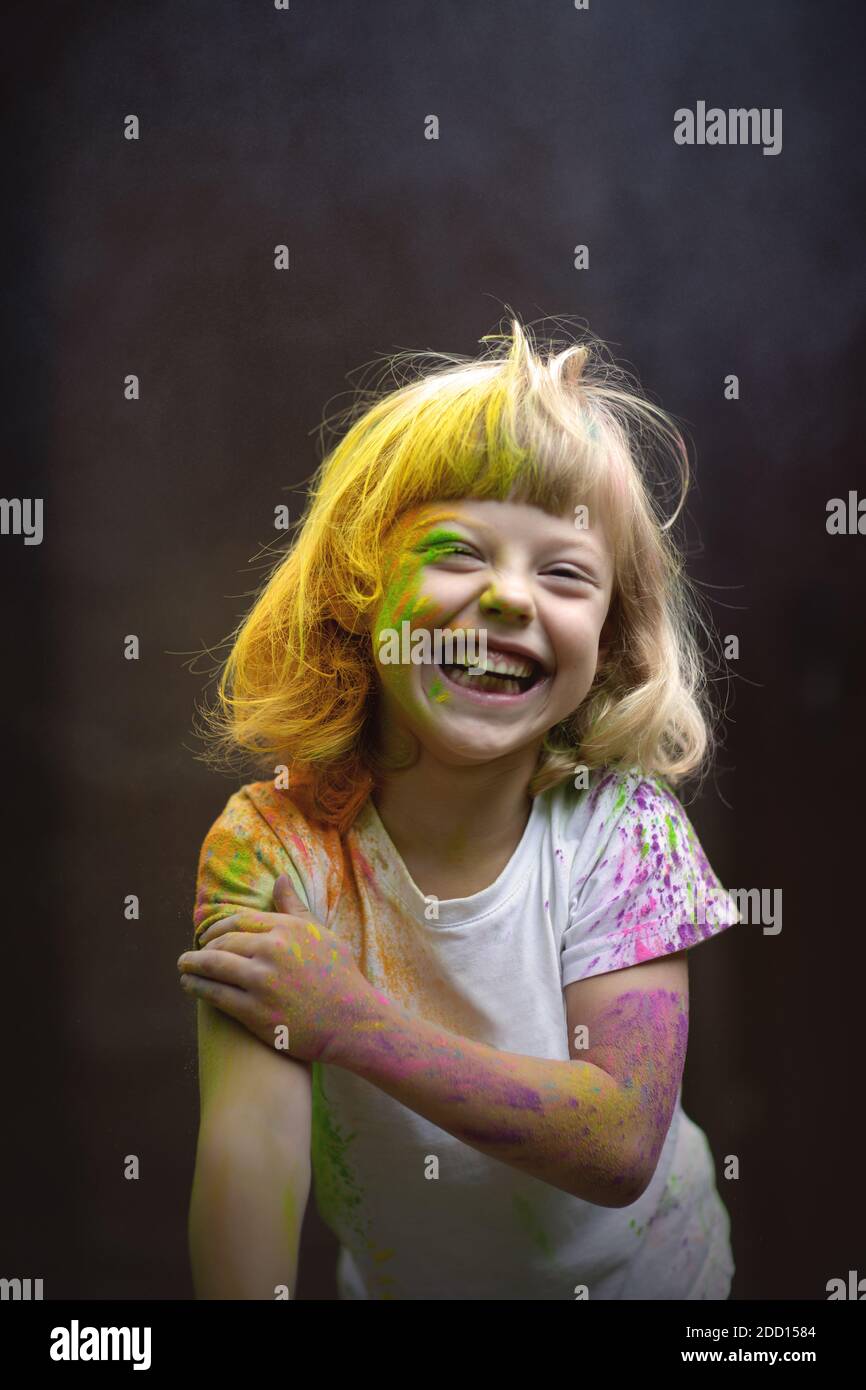 Kleine lustige Mädchen mit Holi Farben spielen. Stockfoto