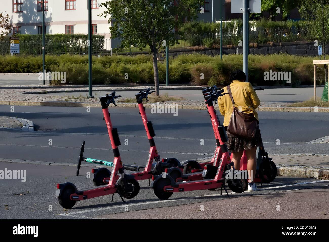 Oslo, Norwegen - 29. August 2020: Frau, die sich ein Elektro-Kick-Fahrrad von der Mietstation in der Stadt ausleihen. Stockfoto