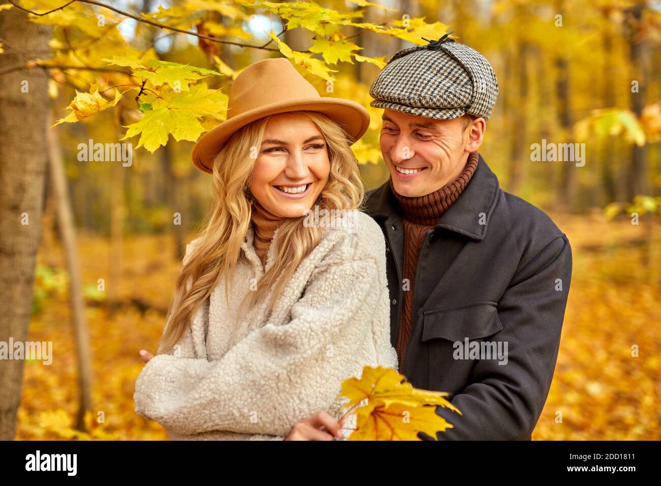 Vermähltes Paar verbringen romantische Zeit im Herbst Park oder Wald, gut aussehende schöne Mann und Frau in Mänteln posiert vor der Kamera um Orangenblätter und Bäume, lächeln Stockfoto Vermähltes Paar verbringen romantische Zeit im Herbst Park oder Wald, gut aussehende schöne Mann und Frau in Mänteln posiert vor der Kamera um Orangenblätter und Bäume, lächeln Stockfoto