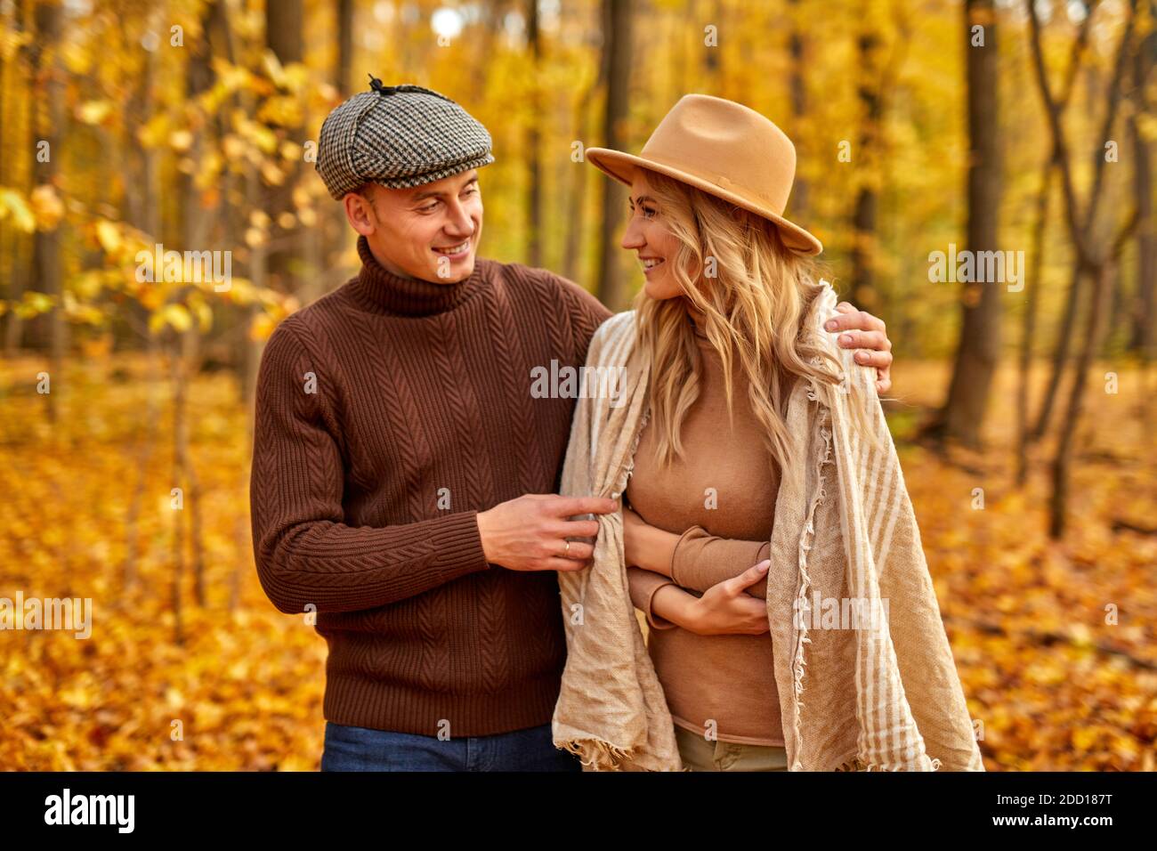 Schöner Mann ist freundlich zu seiner Frau, Liebesgeschichte im Herbst Wald oder Park, verbringen Freizeit zusammen in der Natur, posieren Stockfoto