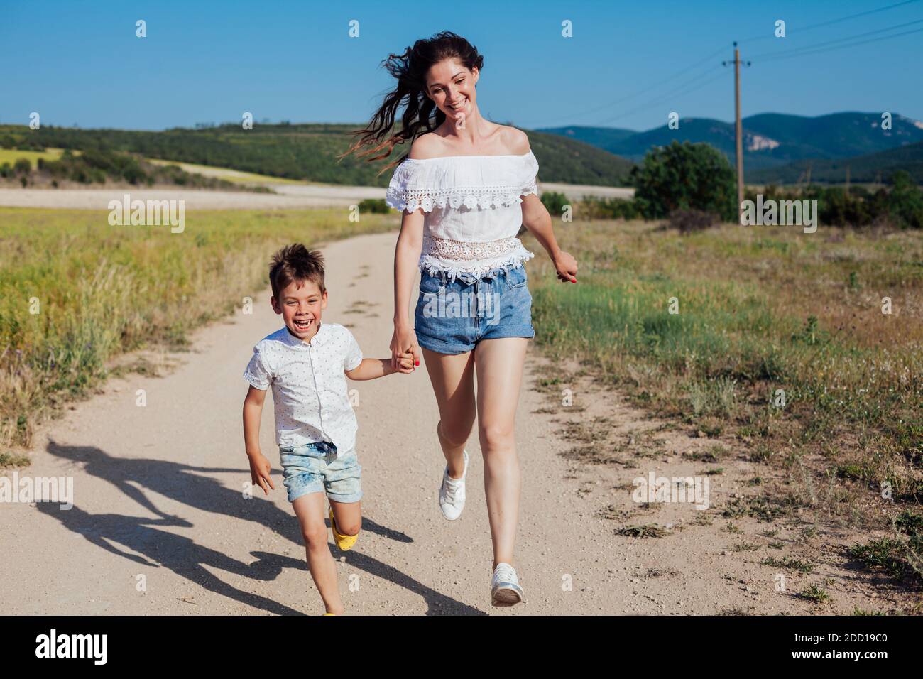 Mama mit jungen Sohn auf einem Spaziergang auf dem Feld Der Sommerfamilie Liebe Stockfoto