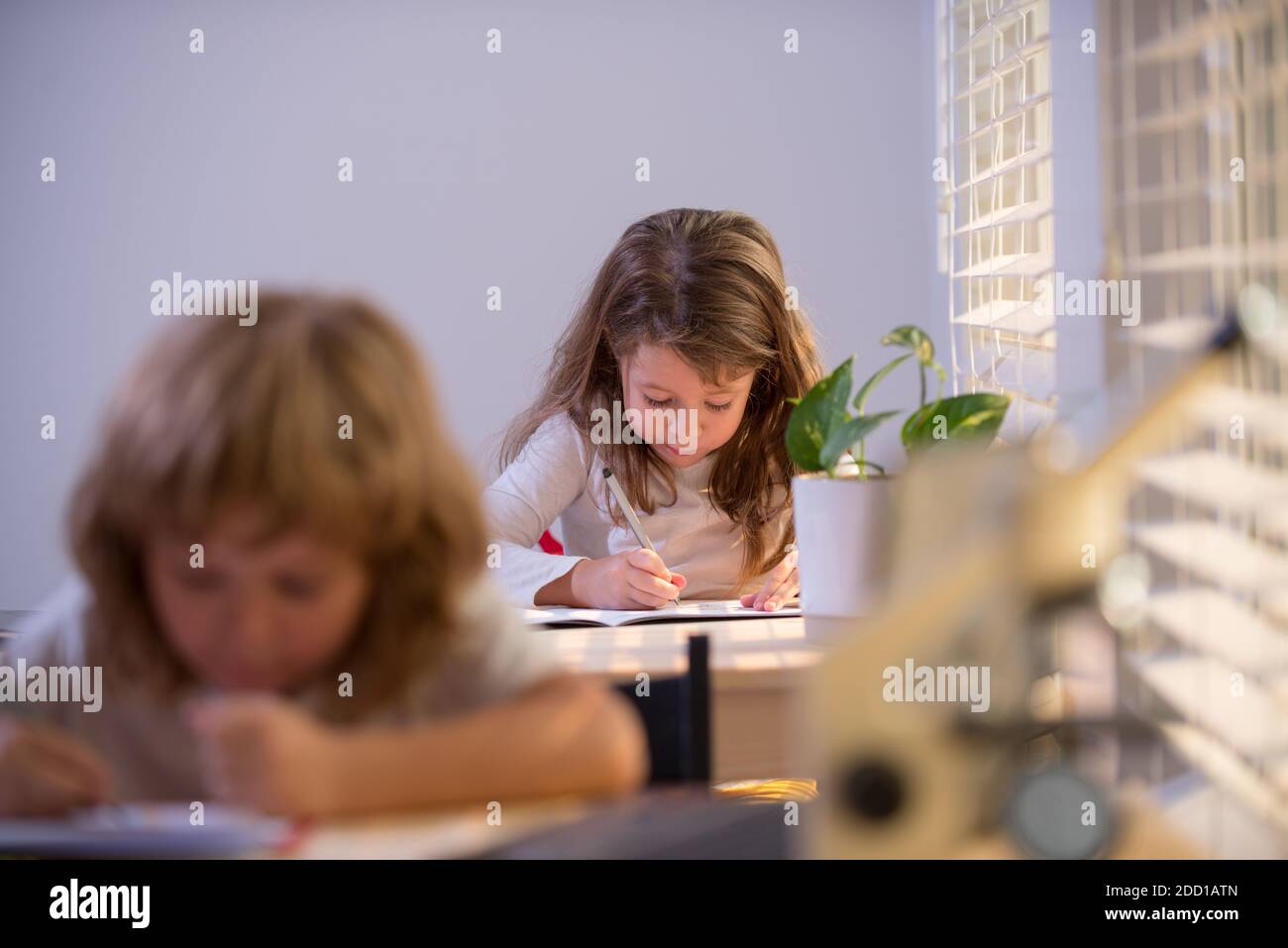 Kinder sitzen am Schreibtisch in der Schule Klassenzimmer und Schreibprüfung. Stockfoto