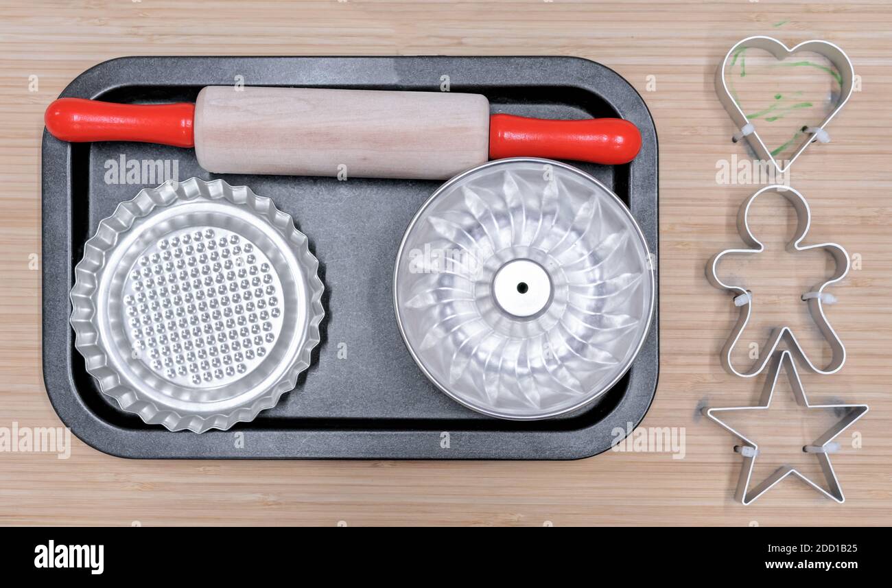 Kinderbackset mit Nudelholz, Muffin und Plätzchenformen. Stockfoto