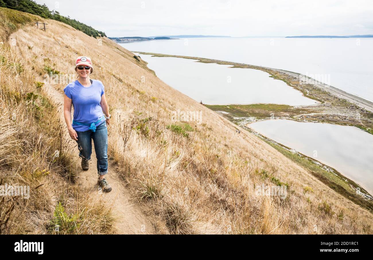 Eine Frau, die auf Ebey's Landing Bluff Trail, Whidbey Island, Washington, USA, läuft. Stockfoto