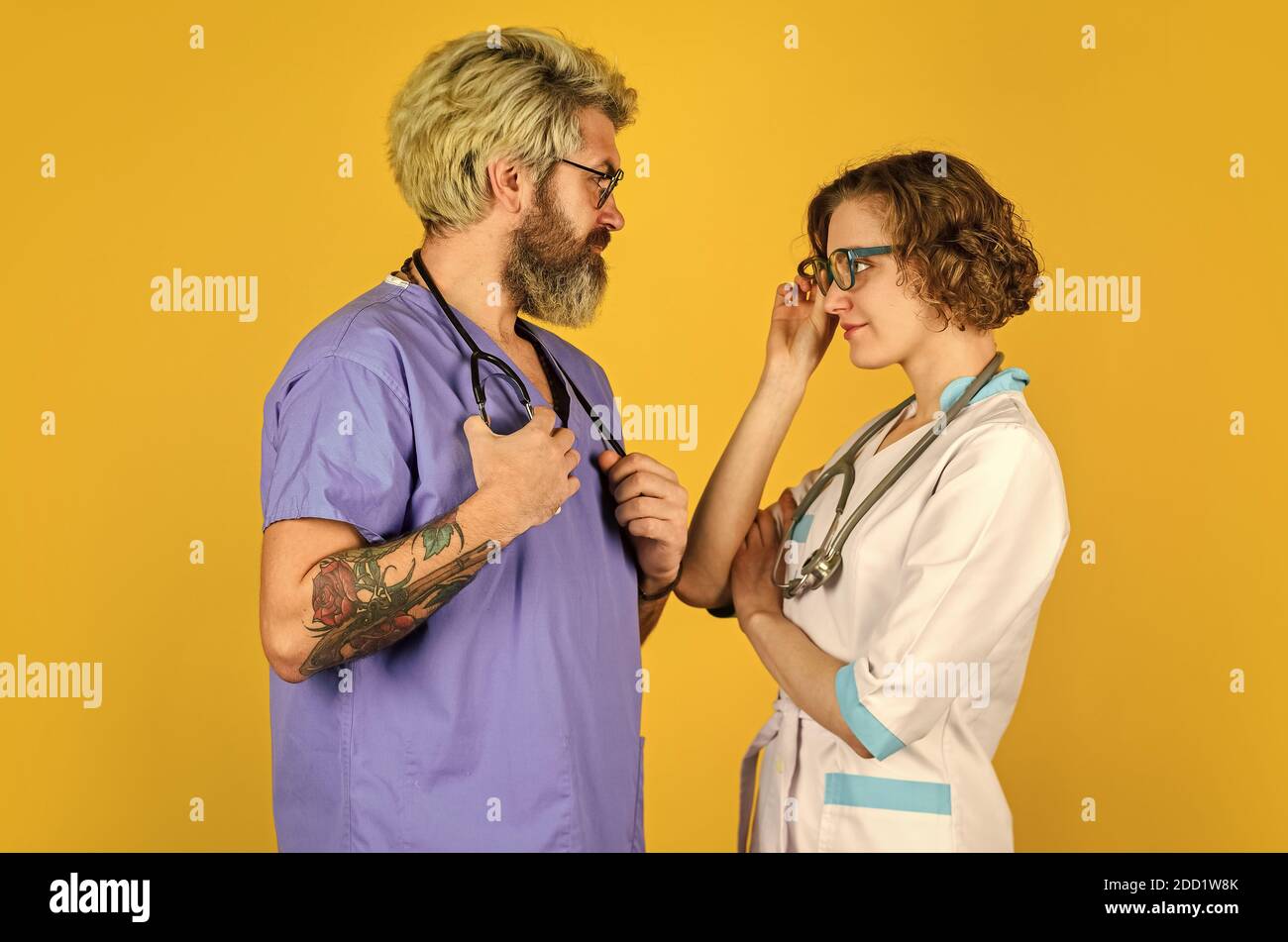 Menschen in Uniformen gelben Hintergrund. Medizinisches Personal. Vertrauen Sie unseren Fachleuten. Healthcare Business. Teamwork und Menschen Konzept. Arzt und Krankenschwester. Erfolgreiches Team von Ärzten. Seien Sie Sicher. Stockfoto