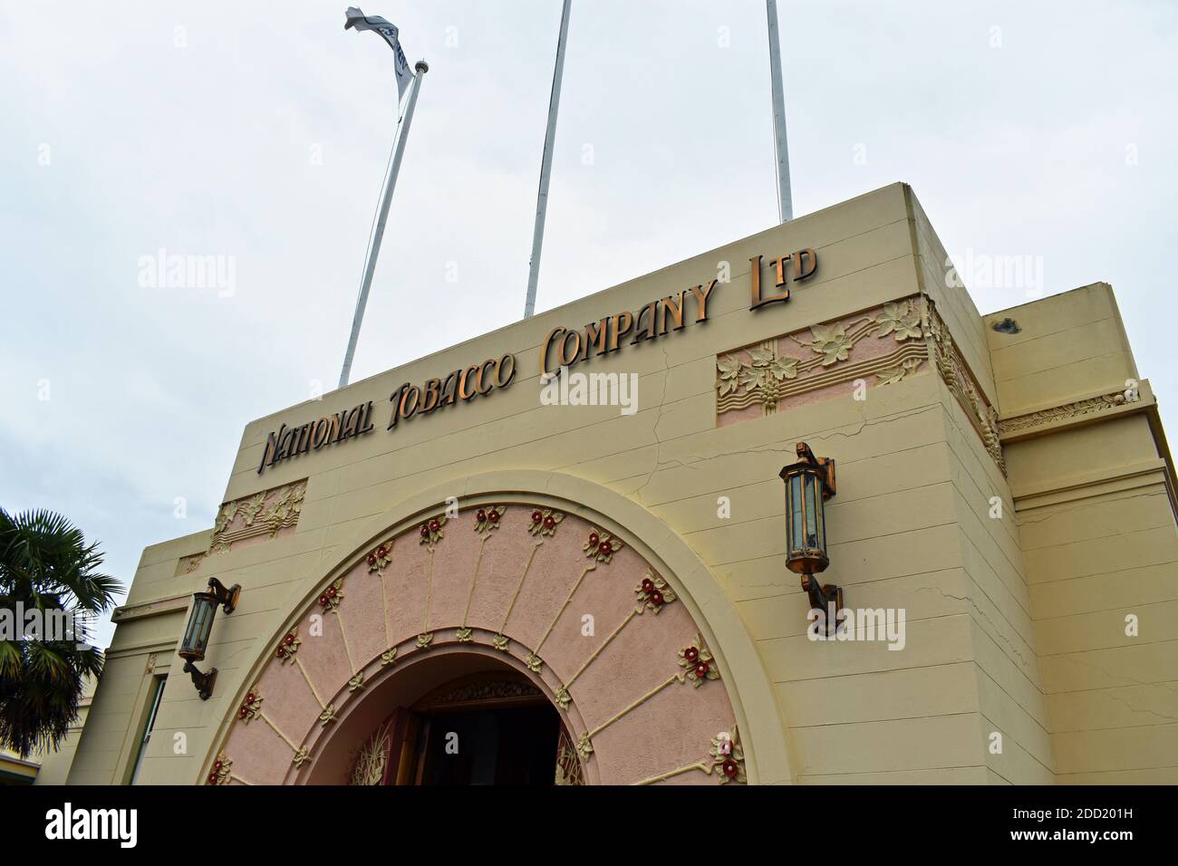 Das Gebäude der Art Deco National Tobacco Company in Napier, North Island, Neuseeland. Dekorative Rosen am Torbogen Eingang und Fahnenmasten oben. Stockfoto