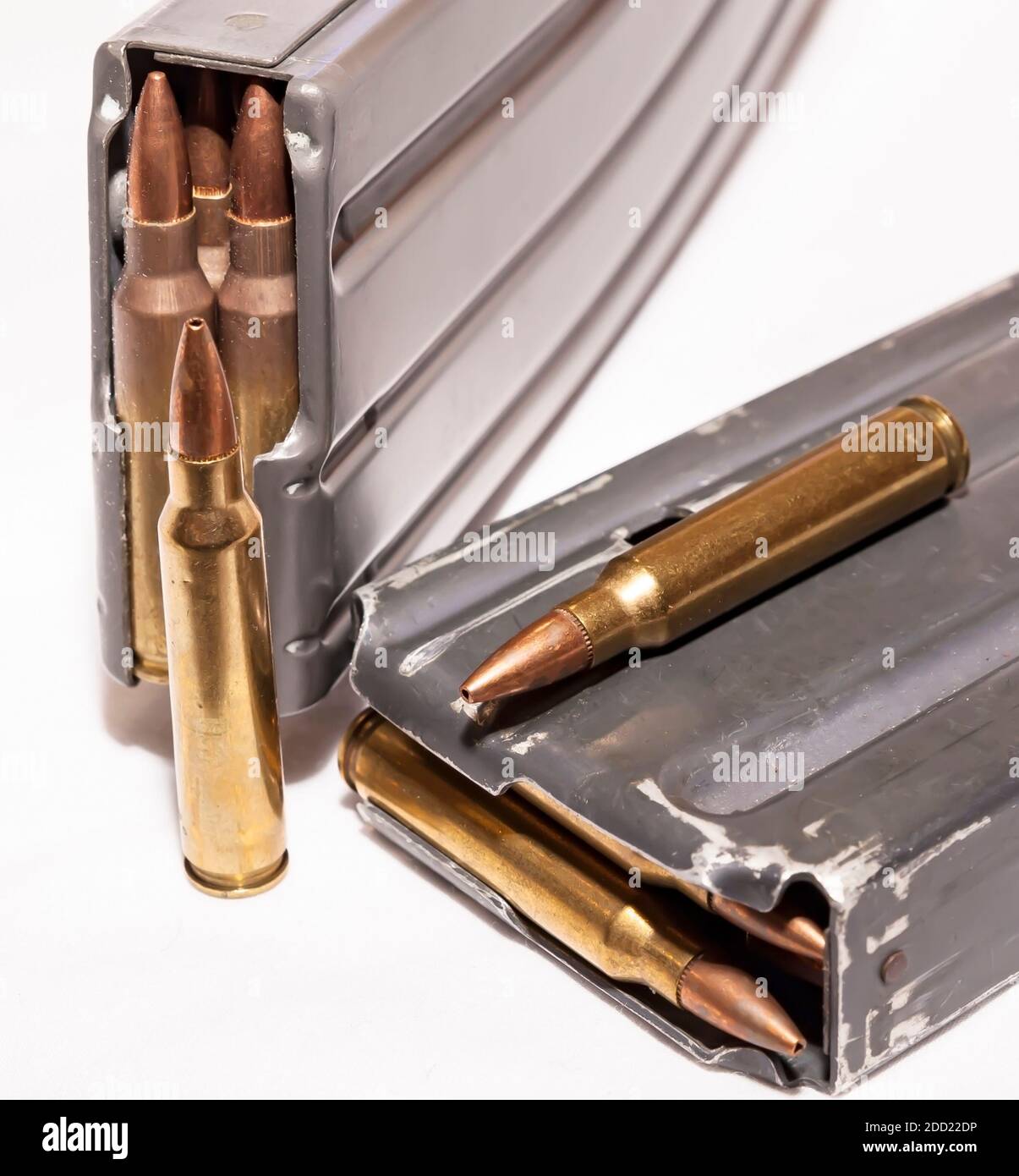 Zwei geladene Gewehrmagazine mit 223 Kaliber Kugeln mit zwei Zusätzliche Aufzählungszeichen außerhalb der Aufzählungszeichen auf weißem Hintergrund Stockfoto