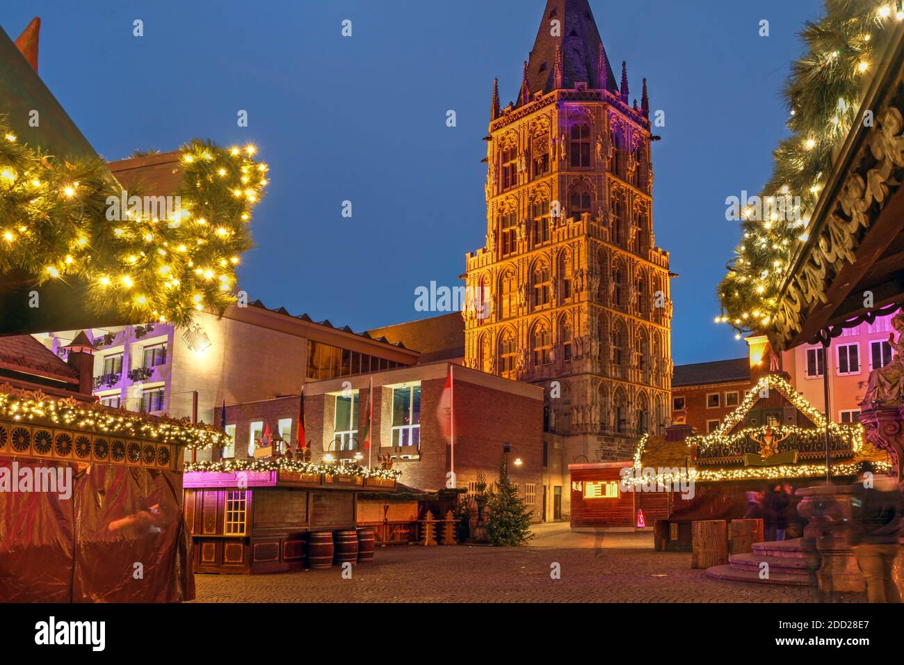 Nachtszene am Rathausplatz in Köln, Deutschland während der Weihnachtszeit, mit dem Weihnachtsmarkt und dem Turm des Rathauses. Stockfoto