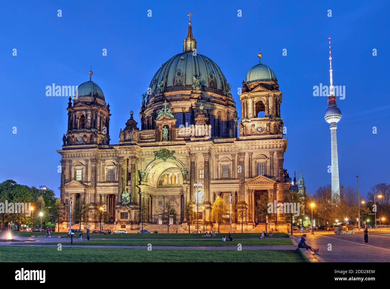 Berliner Dom (oder Berliner Dom, oder Evangelische Oberpfarrei und Stiftskirche) bei Dämmerung mit Fernsehturm im Hintergrund, Stockfoto