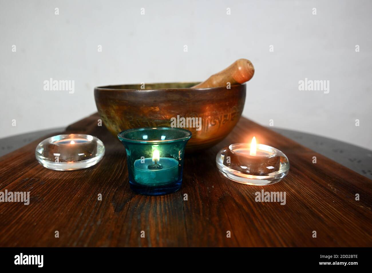 Holztisch. Brennende Kerzen, die eine besondere Atmosphäre schaffen Stockfoto