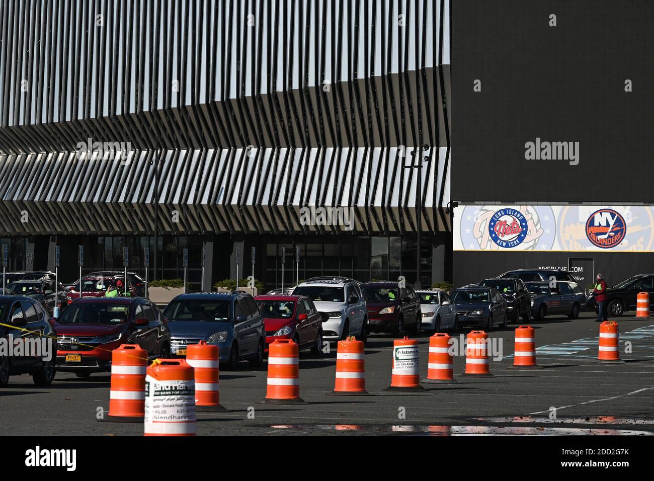 Uniondale, USA. November 2020. Die Leute stehen in ihren Autos, um gespendete Lebensmittel, einschließlich Thanksgiving-Lieferungen, vor Nassau Coliseum in Uniondale, New York, 23. November 2020 zu erhalten. Die Verteilung von etwa 3000 Einheiten von Lebensmitteln, die von Island Harvest Food Bank organisiert wurden, beinhaltete gefrorene Truthähne und Schinken für die kommenden Thanksgiving-Feiertage, da die Menschen angehalten werden, nicht zu reisen und zu Hause zu bleiben, um den Anstieg der COVID-19-Infektionen, die derzeit die Vereinigten Staaten erreichen, einzudämmen. (Anthony Behar/Sipa USA) Quelle: SIPA USA/Alamy Live News Stockfoto