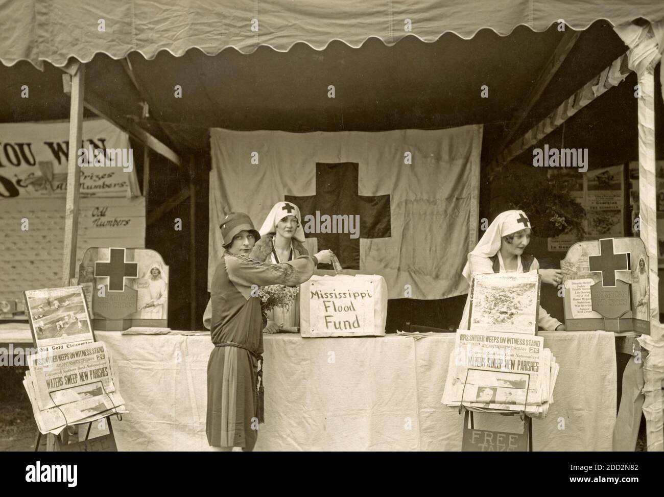 Niemand ist hungrig, ungekleidet, ungeschützt gegangen der DeKalb County Chapter Stand, um Hilfsgelder zu sammeln, war ein Zentrum des Interesses auf einer Messe in Decatur, Georgia - Foto zeigt Mitarbeiter des Roten Kreuzes an einem Stand und eine Frau, die eine Spende an Mississippi Flood Fund, 1927 macht Stockfoto