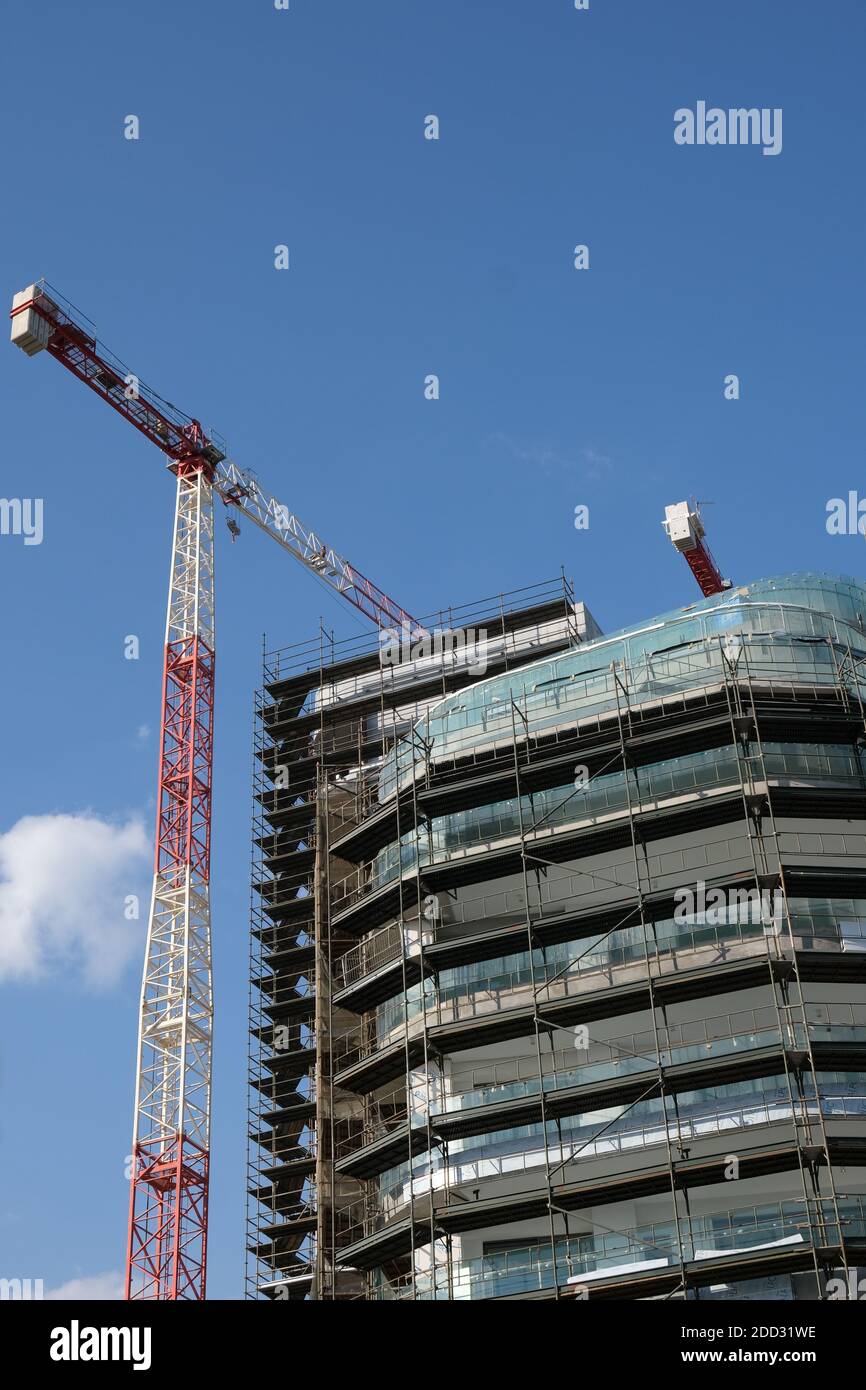 Moderne Wohn-Bürogebäude Baustelle und Kräne während eines lebendigen Tages mit blauem Himmel. Stockfoto