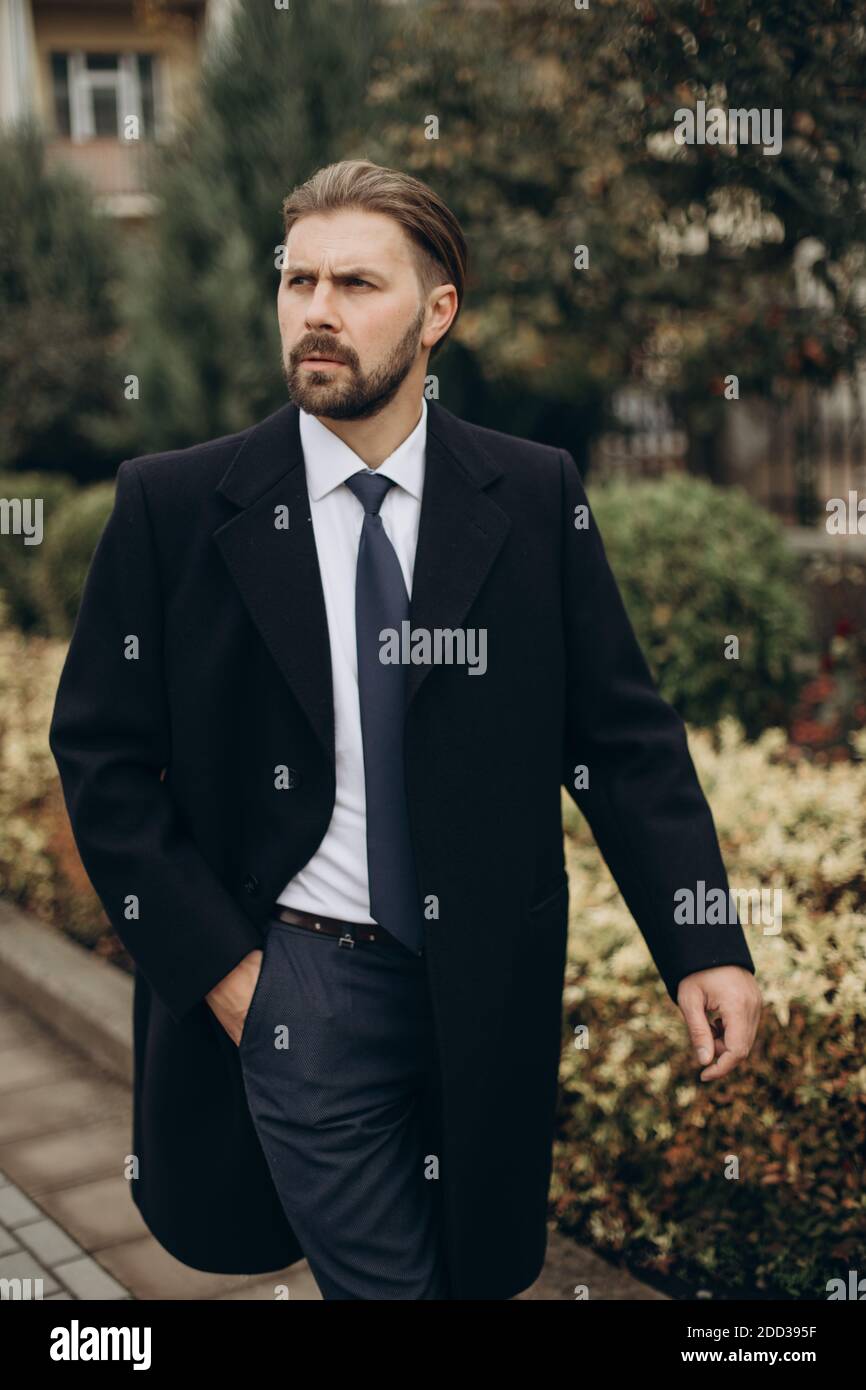 Bärtiger Mann im Anzug, der im Freien läuft Stockfoto