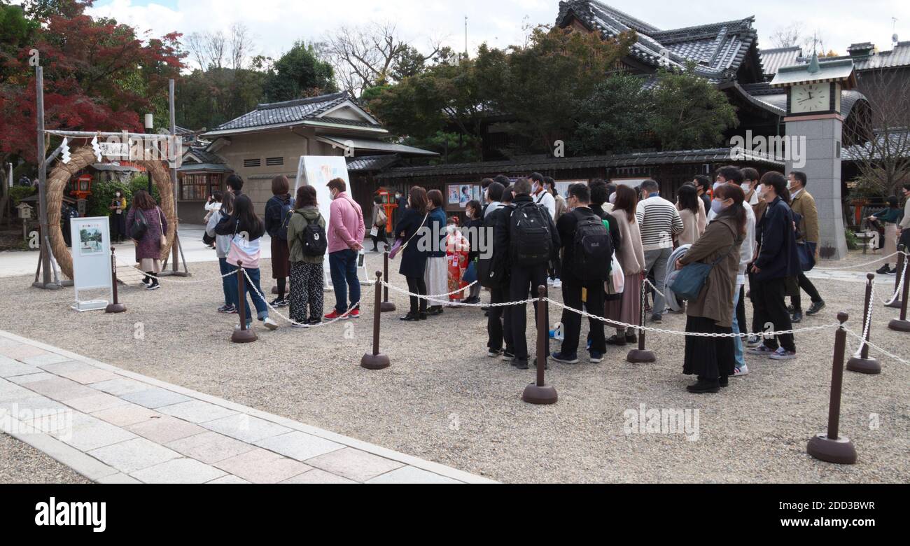 Gläubige, die Gesichtsmasken tragen, um die Ausbreitung des neuartigen Coronavirus zu verhindern, passieren am 22. November 2020 den Chinowa am Yasaka-Schrein in Kyoto, Japan. Quelle: AFLO/Alamy Live News Stockfoto