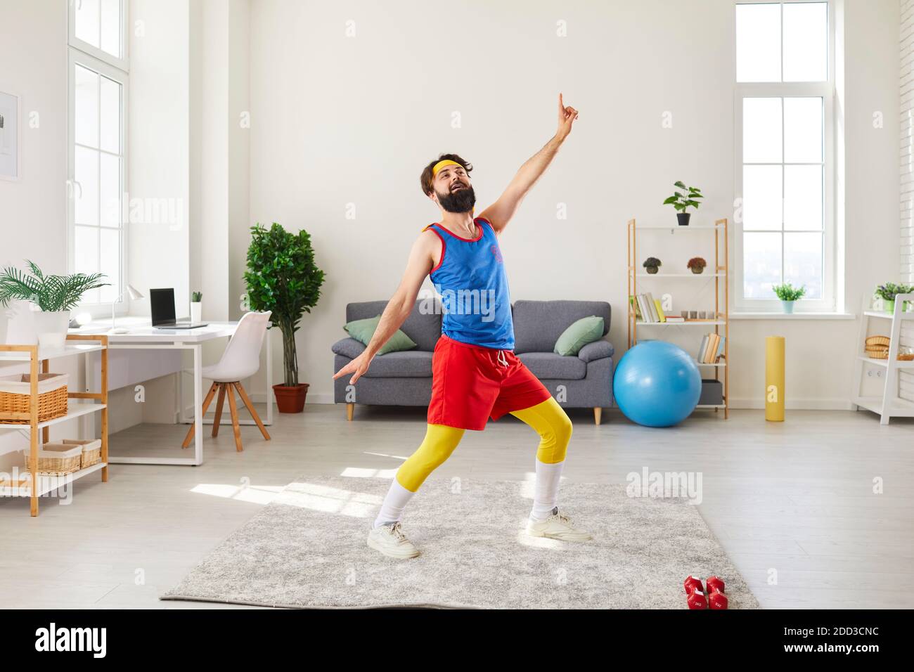 Lustige Mann tun Fitness-Übung, Tanzen und Herumduppen während des Trainings zu Hause Stockfoto