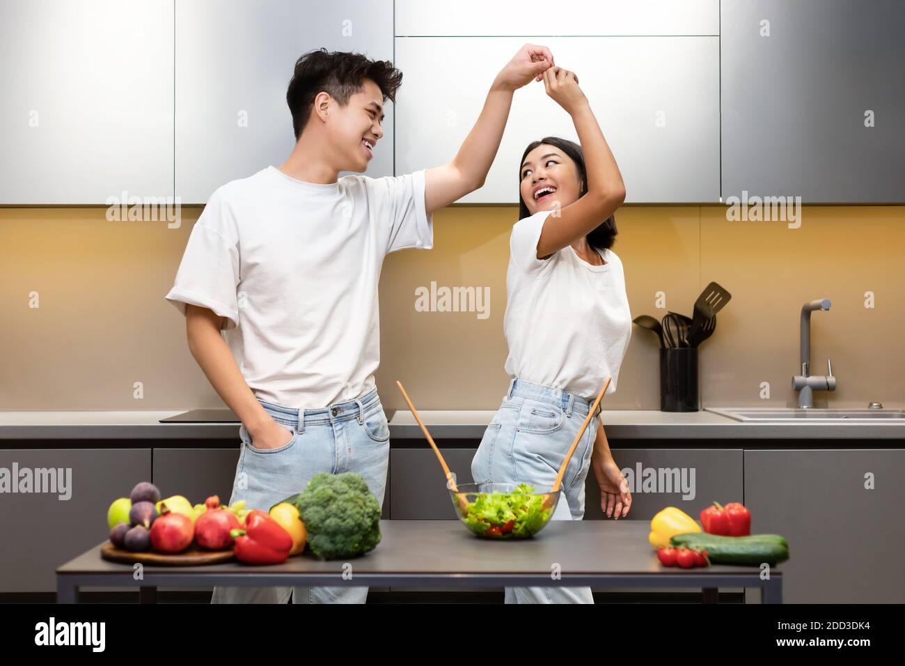 Fröhliche Japanische Paar Tanzen Und Lachen In Moderne Küche Stockfoto