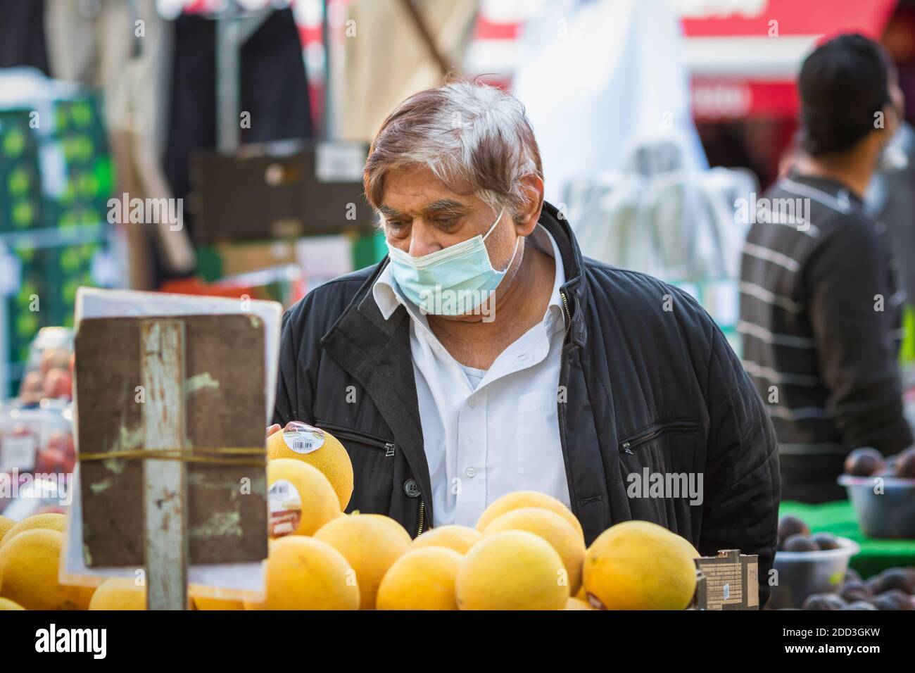 London, Großbritannien - 3. November 2020 - EIN älterer asiatischer Mann mit Gesichtsmaske beim Einkaufen auf dem Walthamstow Markt Stockfoto