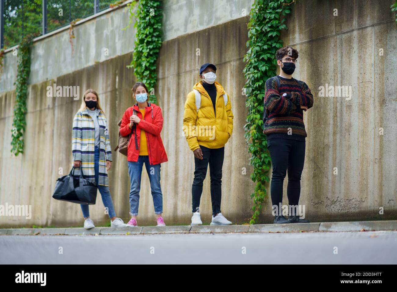 Junge Menschen stehen im Freien in der Stadt. Coronavirus und sicheres Entfernungskonzept. Stockfoto