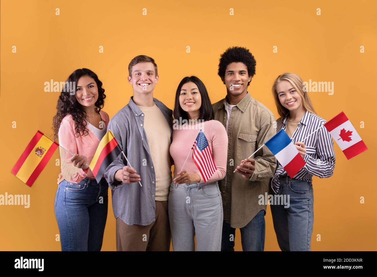 Smilinge multi ethnischen Schüler in casual, halten kleine Fahnen Stockfoto