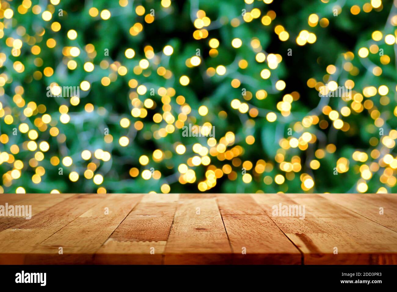 Holztischplatte mit Bokeh aus dekorativem Licht an weihnachten Baum im Hintergrund Stockfoto