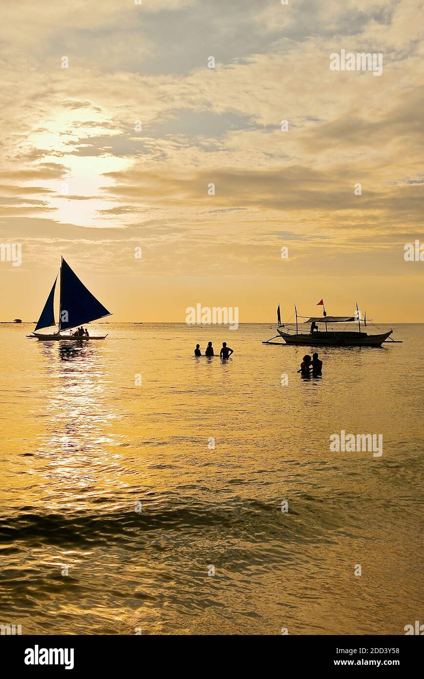 Silhouette von zwei Booten und Touristen bei einem goldenen Sonnenuntergang am Weißen Strand auf Boracay Island, Aklan Provinz, Visayas, Philippinen, Asien Stockfoto