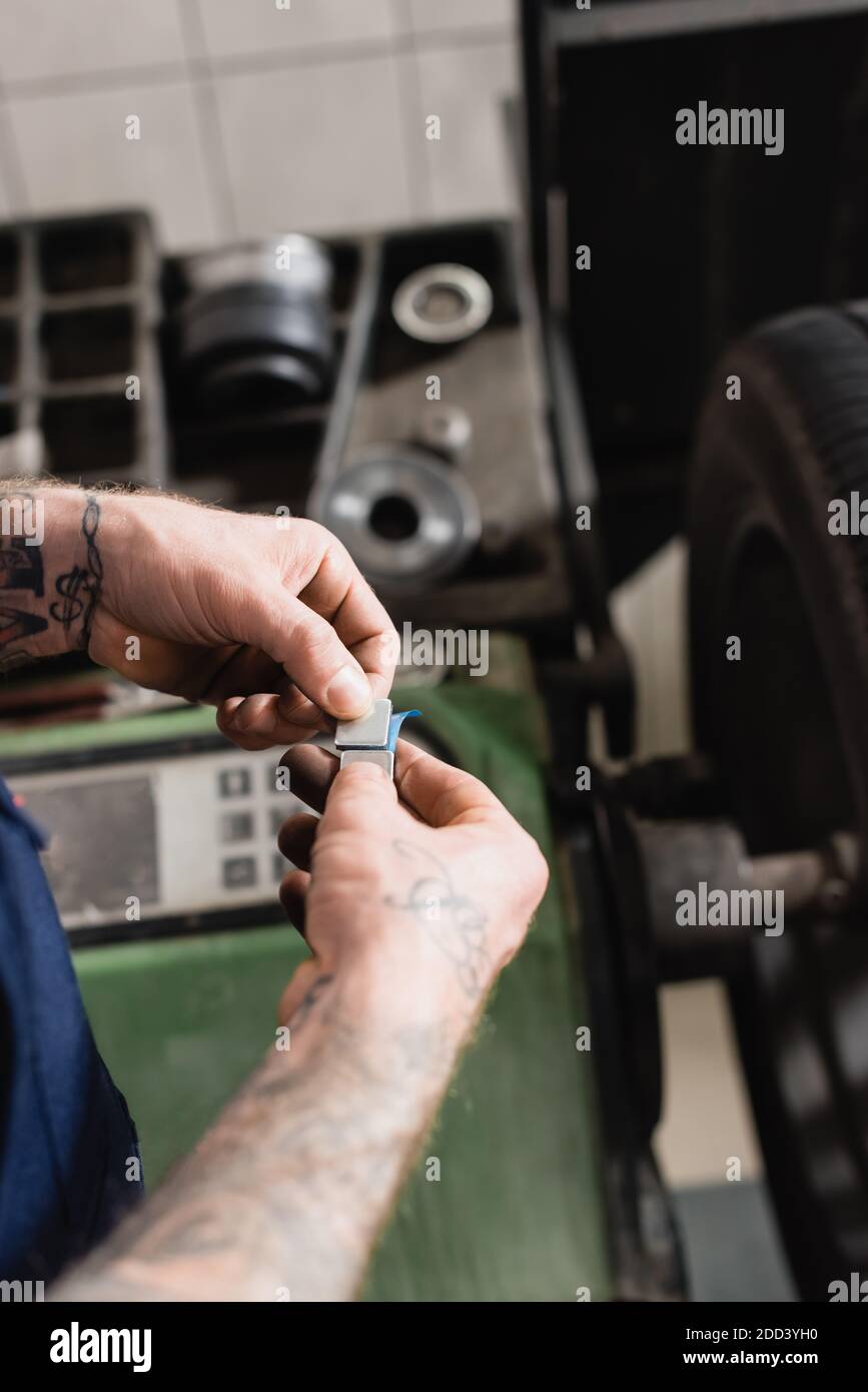 Teilansicht des mechanischen Entfernens der metallischen Ausgleichsplatte vom Klebstoff Kontrollmaschine für die Nahausgleichs-Streifen auf unscharfem Hintergrund Stockfoto