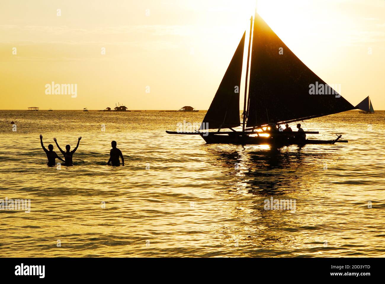 Silhouette eines Segelbootes und Touristen bei einem goldenen Sonnenuntergang am Weißen Strand auf Boracay Island, Aklan Provinz, Visayas, Philippinen, Asien Stockfoto