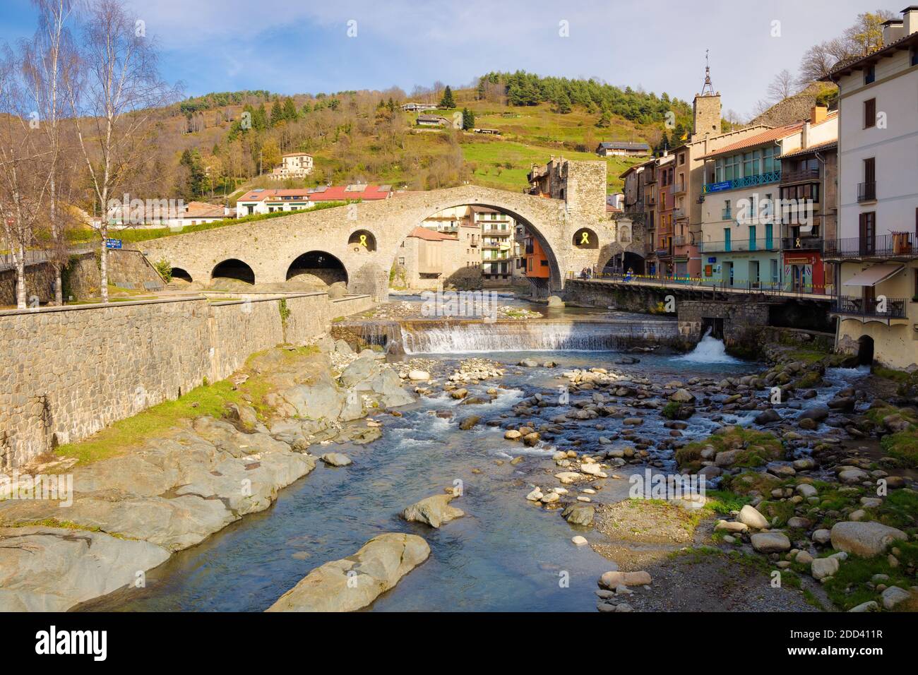 Blick auf die Neue Brücke aus dem 12. Jahrhundert eines Morgens mitten im Herbst, wo einige Leute spazieren gehen. Camprodon, Katalonien, Spanien. Stockfoto