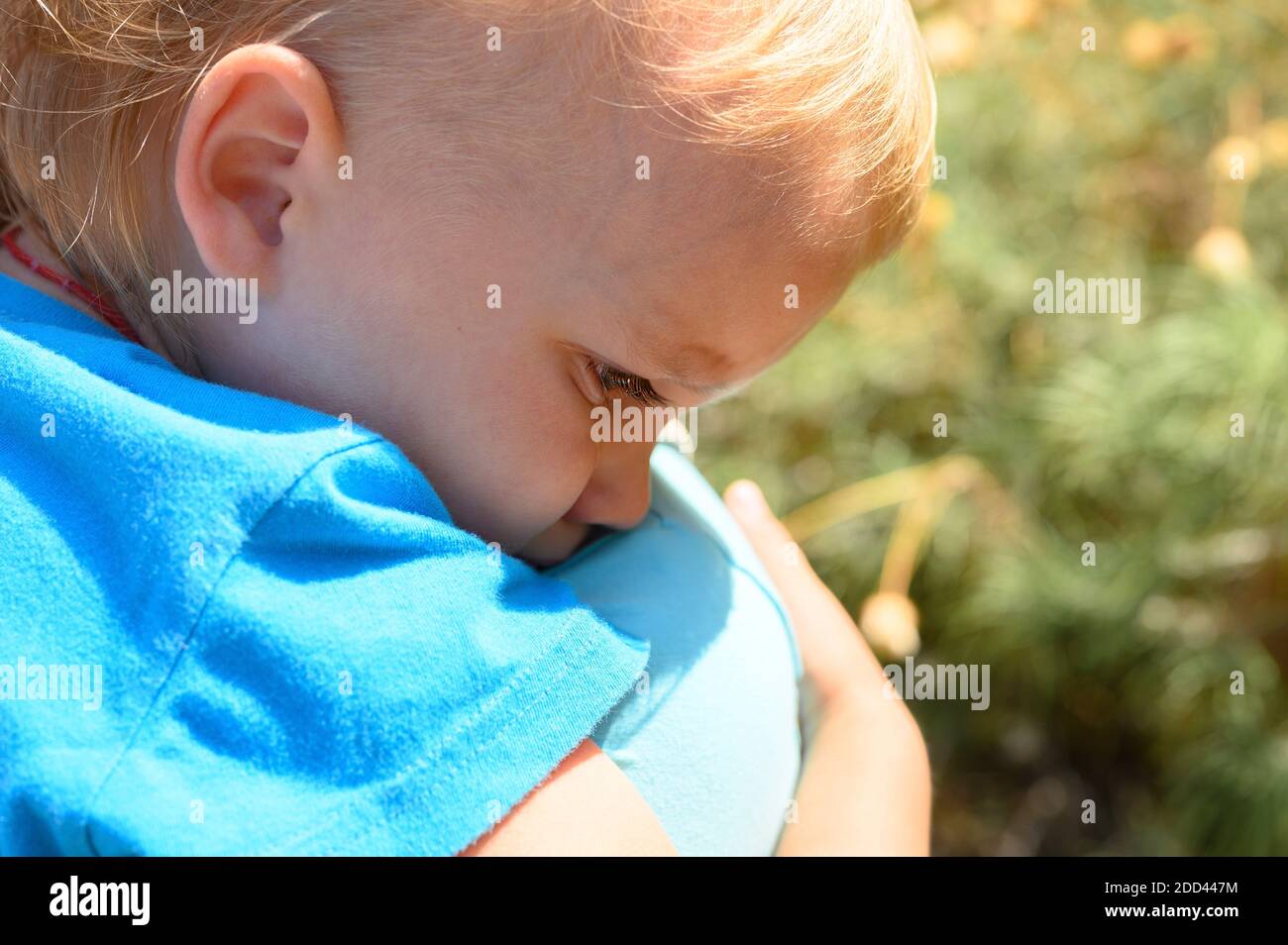 Süßes kleines verärgert Baby Junge weinend auf der Schulter der Mutter in den Armen seiner Mutter, umarmt seine Mutter Stockfoto