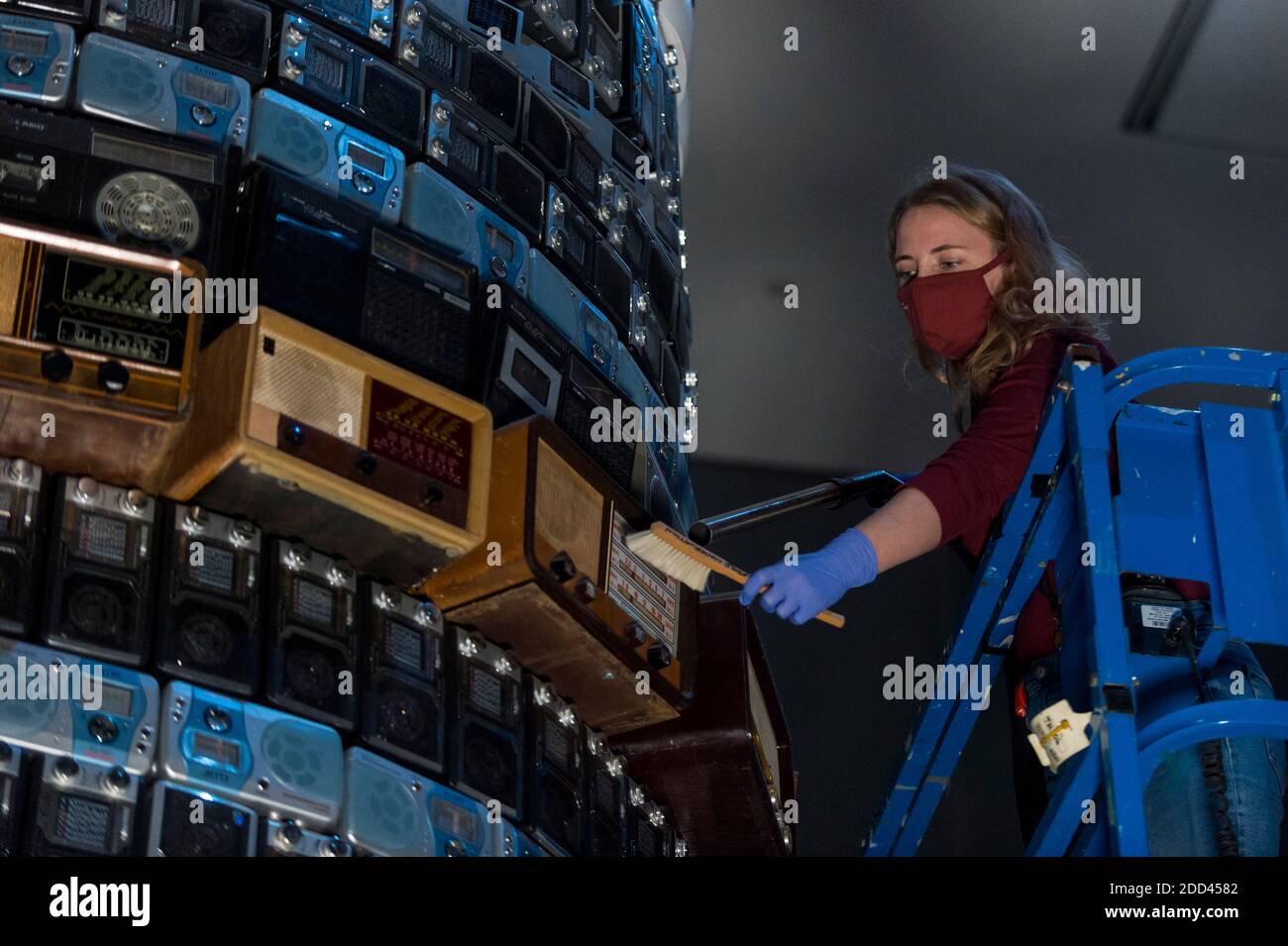 London, Großbritannien. 24. November 2020. Ein Konservator der Tate führt eine Spezialreinigung der 8m hohen, hoch aufragenden skulpturalen Installation Babel 2001 von Cildo Meireles durch. Das Kunstwerk besteht aus Hunderten von Radios unterschiedlichen Alters, die auf eine Vielzahl von Stationen abgestimmt sind, die zusammen eine Kakophonie von niedrigem, durchgehendem Klang erzeugen. Da die Tate-Galerien derzeit während der Sperrung der Coronavirus-Pandemie geschlossen sind, haben Konservatoren die Möglichkeit, die nationale Sammlung fachlich zu betreuen. Kredit: Stephen Chung / Alamy Live Nachrichten Stockfoto