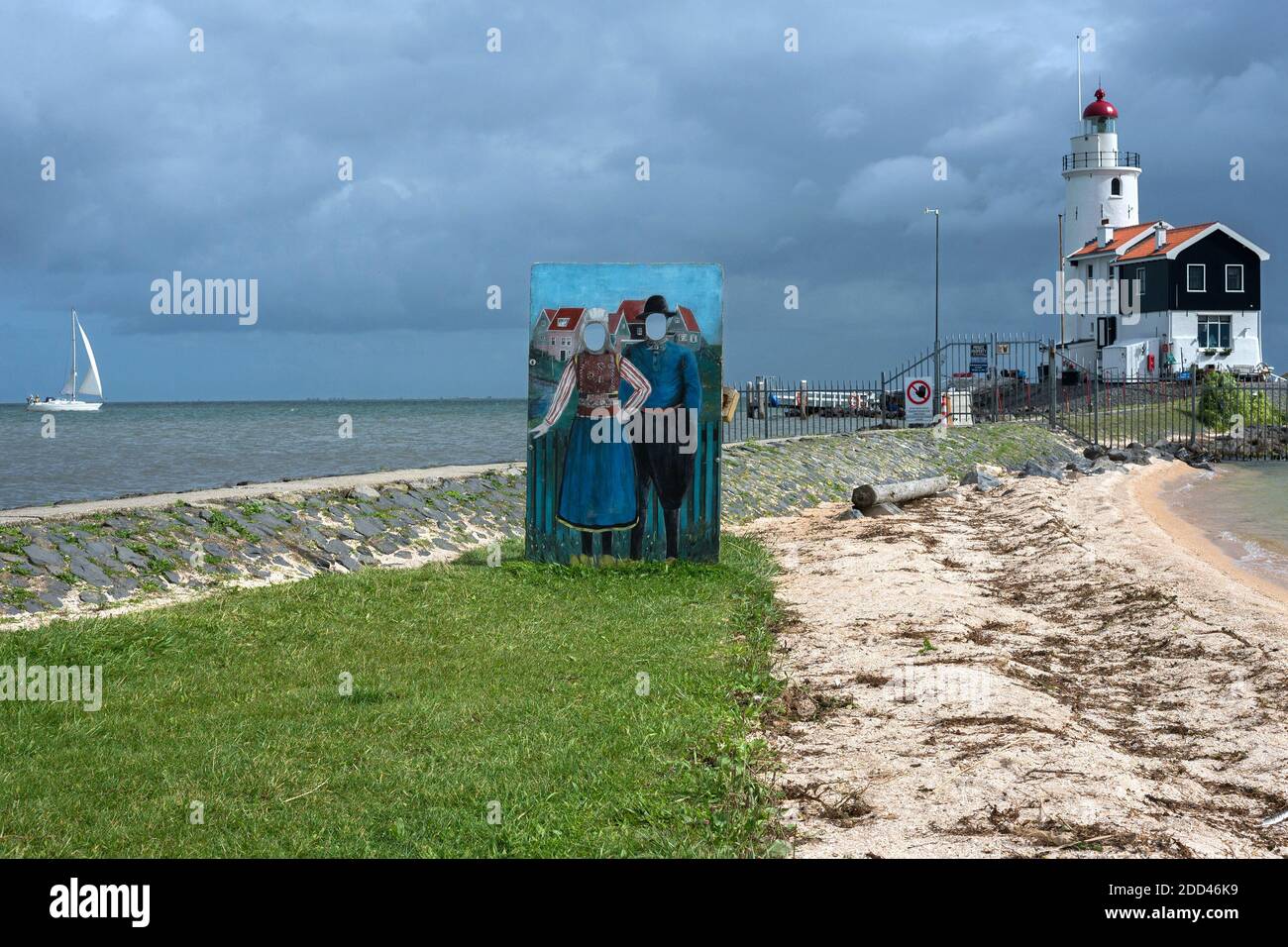 Marke Insel,Holland:Silhouette für Souvenir Foto in der Nähe des Leuchtturms der Insel Marken, zeigt ein Paar in typisch holländischen Kostümen. Stockfoto
