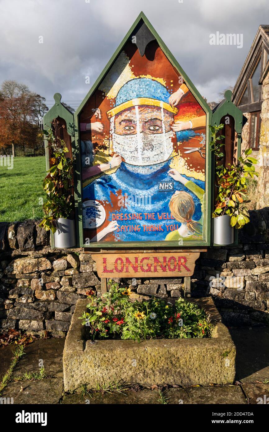 Während der Aussperrung wurden traditionelle Peak District Brunnenauflagen von Blumen abgesagt, so dass sie im Dorf Longnor diese Hommage an den NHS gemalt haben. Stockfoto