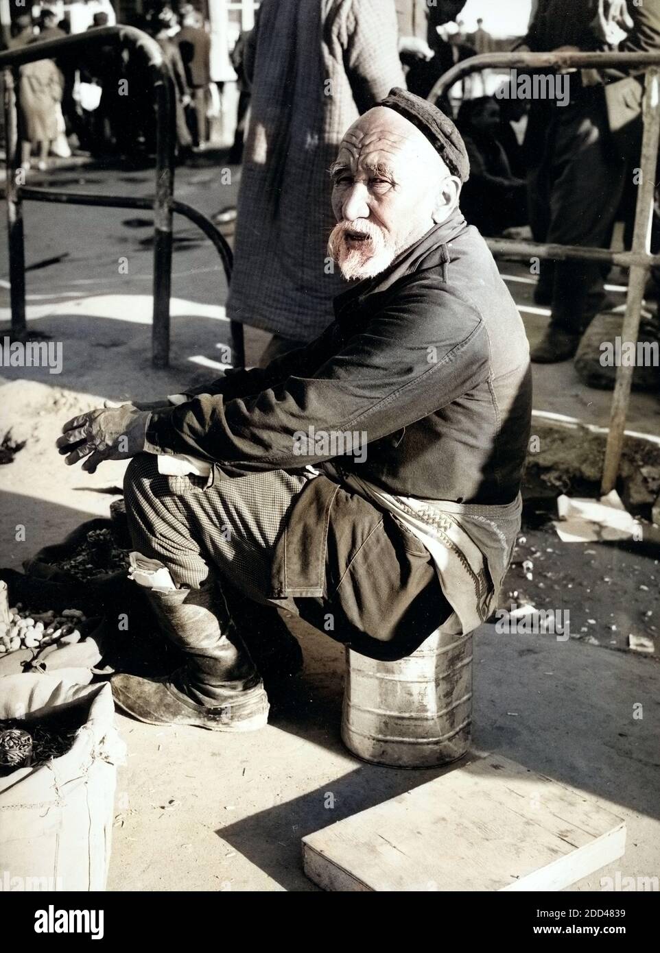 Ein Mann Sitzt Hinter seit Verkaufsstand Auf Dem Basar in Taschkent in Usbekistan, Bezirkshandstempel, 1970er Jahre. Ein Mann sitzt hinter seinem Stand auf dem Markt in Taschkent in Usbekistan, Sowiet-Union, der 1970er Jahre. Stockfoto