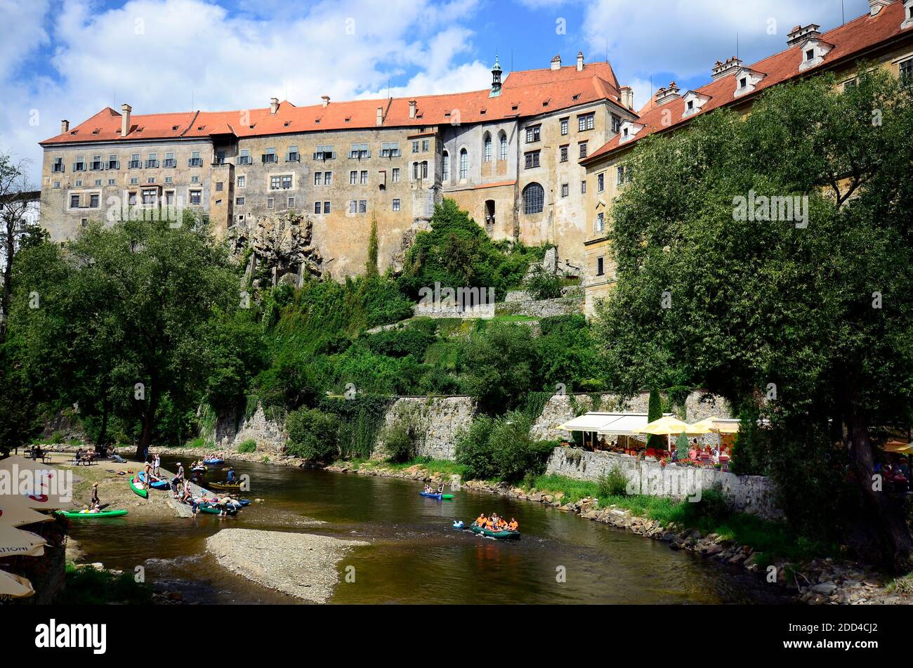 Cesky Krumlov, Tschechische Republik - 11. August 2013: Nicht identifizierte Touristen in Gummiflößen und Kanus auf Moldau (Moldau) und der beeindruckenden Burg Stockfoto