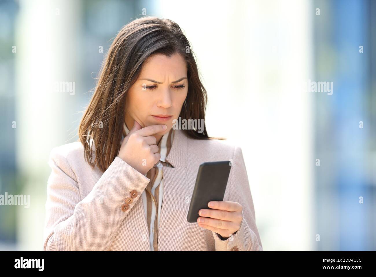 Besorgt Geschäftsfrau Lesung Nachricht am Telefon zu Fuß in der Straße Stockfoto