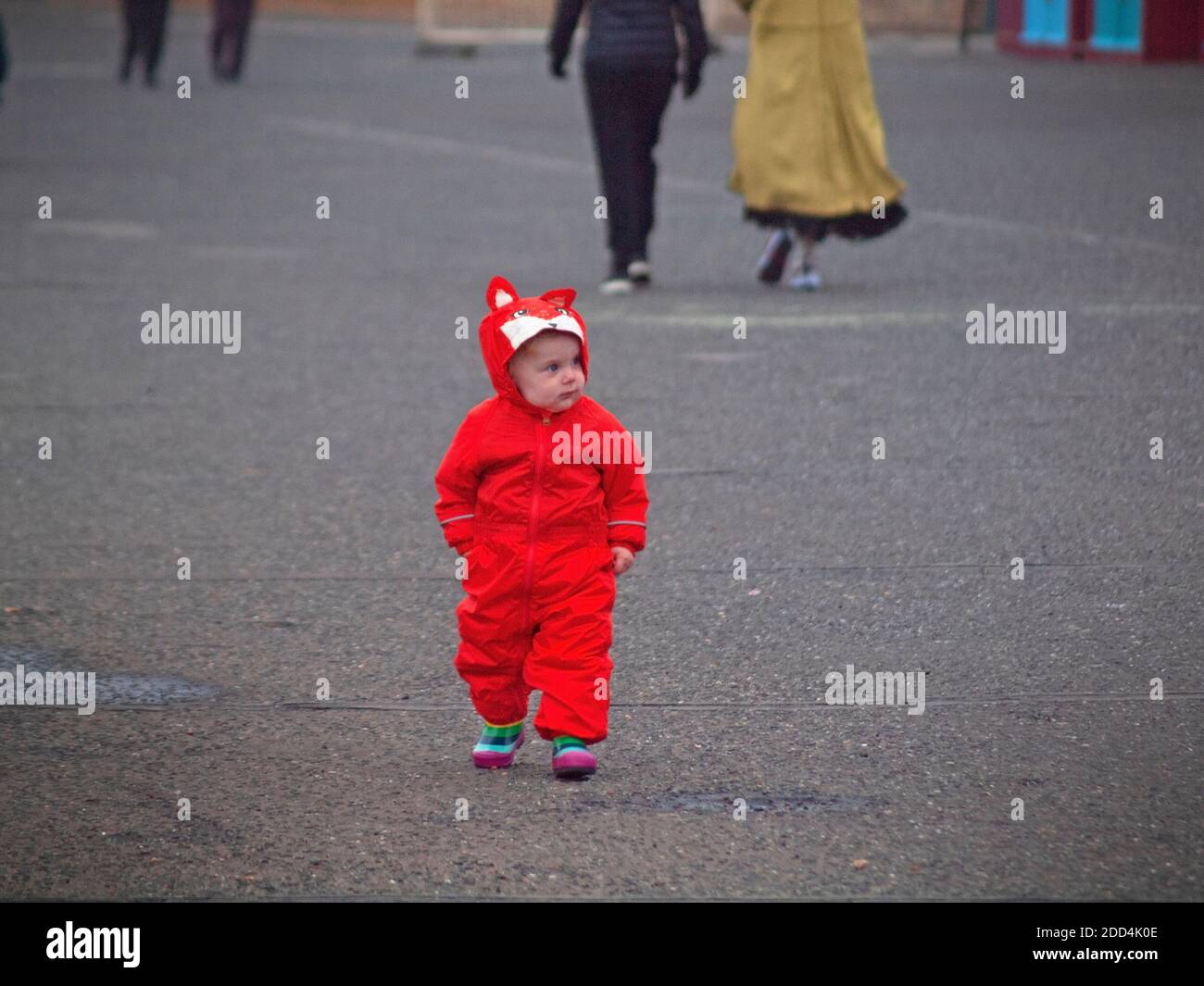 Ein kleines Kind in rot an der Strandpromenade von Brighton Stockfoto