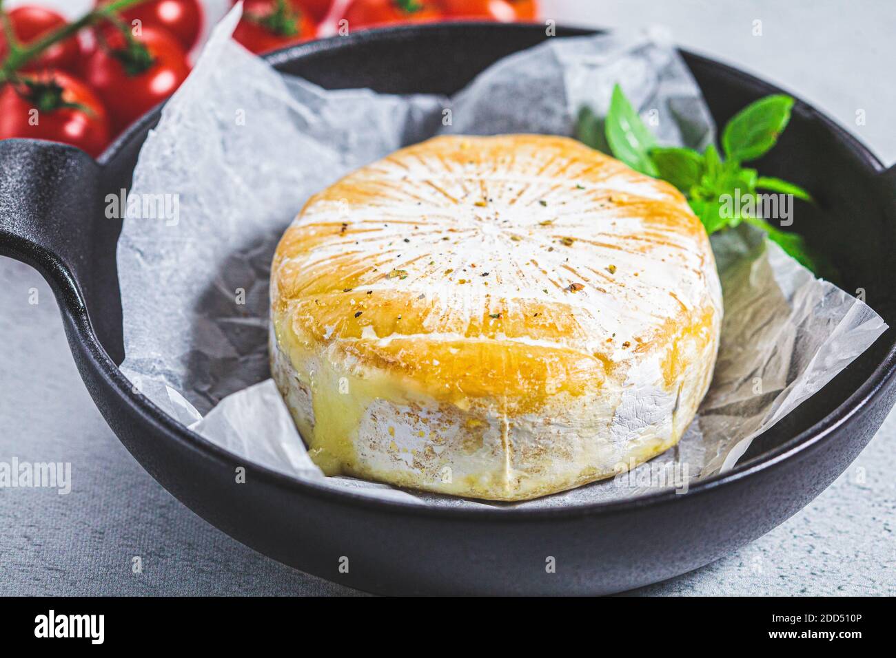 Gebackenen Camembert oder Brie Käse in einer schwarzen Pfanne. Stockfoto