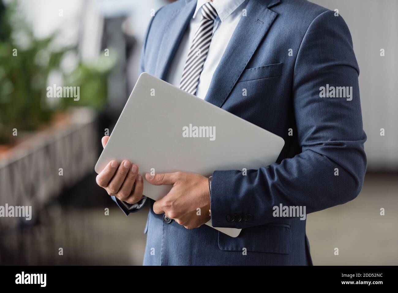 3/4-Ansicht der Geschäftsführerin in formeller Kleidung mit Laptop Unscharfer Hintergrund Stockfoto