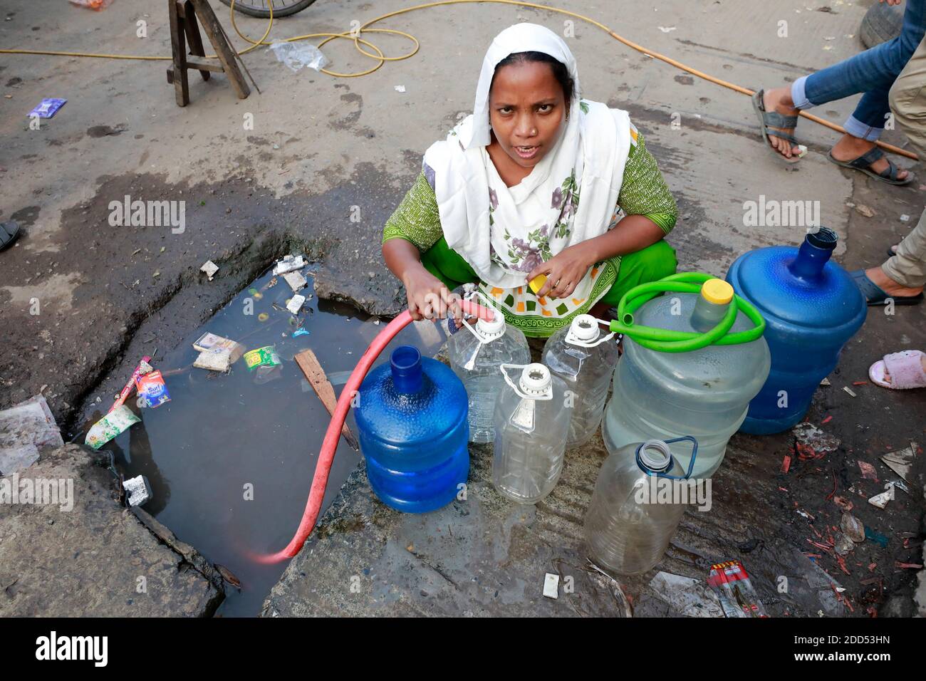 Dhaka, Bangladesch - 24. November 2020: Bewohner von Fulbari in Dhaka, Bangladesch, sammeln Wasser aus einer Straßenleitung. Die Wasserkrise hat sich in t akut Stockfoto