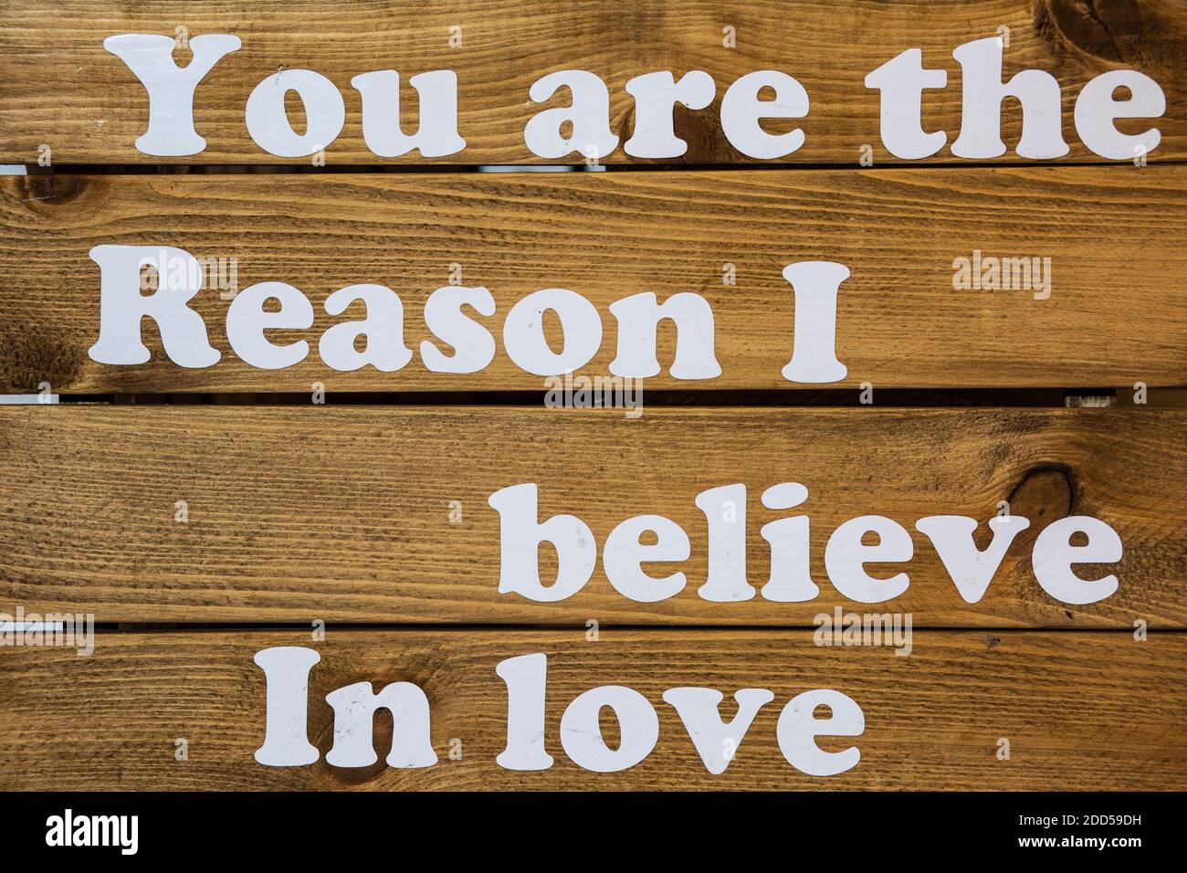 Sie sind der Grund, warum ich an Liebe glaube Text auf Holzbrett Stockfoto