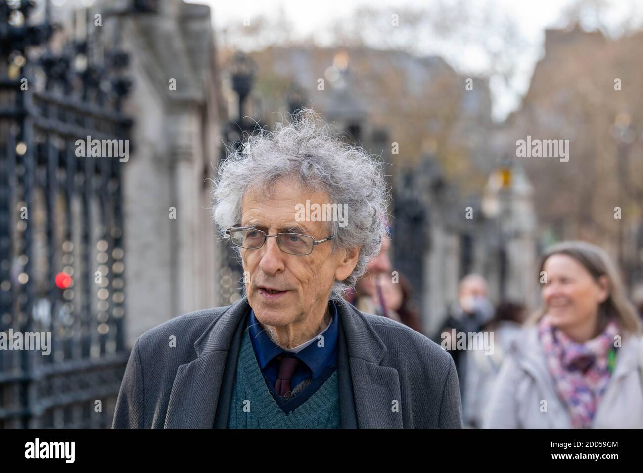 London, Großbritannien. November 2020. Piers Corbyn (Bruder des ehemaligen Labour-Führers Jeremy Corbyn) führte einen kleinen Anti-vax-Anti-Maskenprotest an und verteilte Maskenausnahmemarken an Passanten und die Medien. Er wurde von einem Mann begleitet, der eine riesige Spritze trug, der von der Polizei auf der Westminster Bridge befragt wurde. Kredit: Ian Davidson/Alamy Live Nachrichten Stockfoto